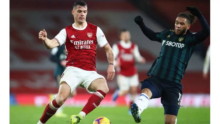 Granit Xhaka of Arsenal (left) fights for ball possession against Tyler Roberts of Leeds United