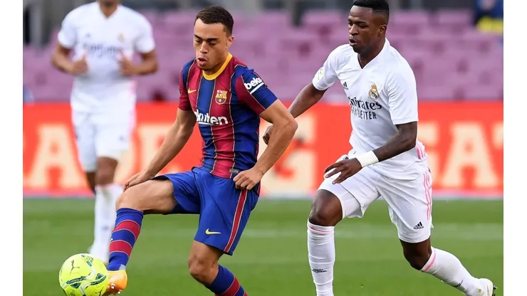 Sergino Dest of Barcelona battles for possession with Vinicius Junior of Real Madrid
