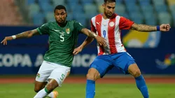 Adrian Jusino of Bolivia (left) fights for ball control against Gabriel Avalos of Paraguay