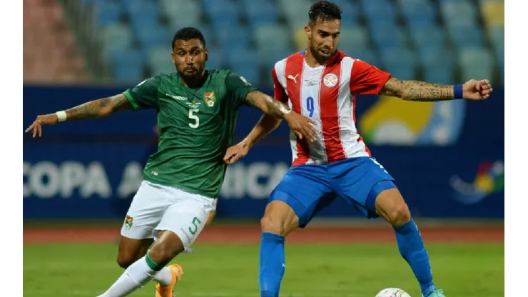 Adrian Jusino of Bolivia (left) fights for ball control against Gabriel Avalos of Paraguay