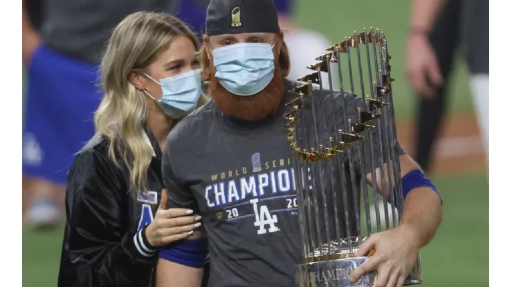 Kourtney Pogue and Justin Turner of the Dodger (right) holding the Commissioner's Trophy after winning MLB championship.