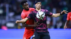Alphonso Davies of Canada battles for possesion with Raúl Jimenez of Mexico.