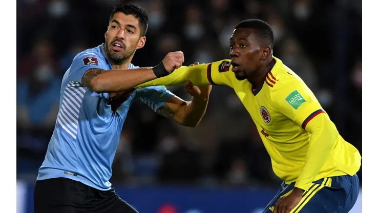Luis Suarez of Uruguay struggles with Carlos Cuesta of Colombia.