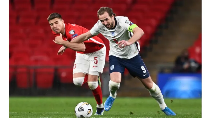 Jan Bednarek of Poland (left) fights for ball control against Harry Kane of England (right) (Getty)