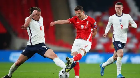 Kalvin Phillips of England (left) fights for ball control against Arkadiusz Milik of Poland (middle) (Getty)