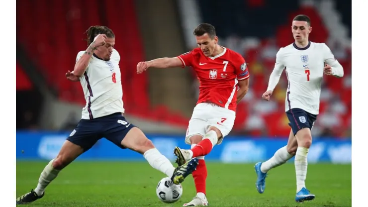 Kalvin Phillips of England (left) fights for ball control against Arkadiusz Milik of Poland (middle) (Getty)