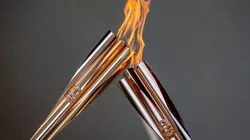 Torch bearers exchange the flame during the Olympic Torch Relay Celebration. (Getty)