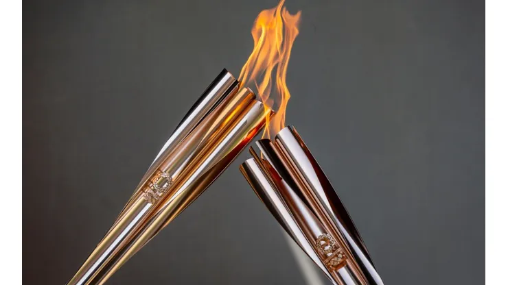 Torch bearers exchange the flame during the Olympic Torch Relay Celebration. (Getty)