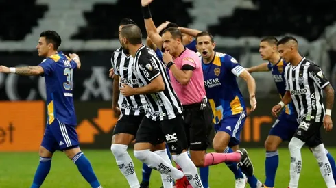 Referee Esteban Ostojich gestures after a VAR review for a possible goal for Boca Juniors as players react during a round of sixteen second leg match between Atletico Mineiro (Getty)