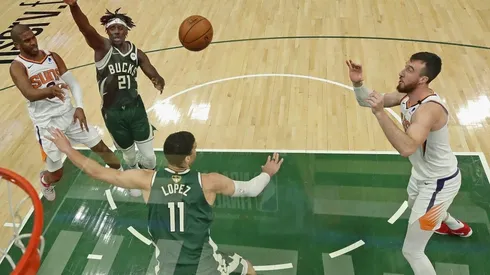 Chris Paul passes the ball to Frank Kaminksy while Brook Lopez and Jrue Holiday play defense. (Getty)