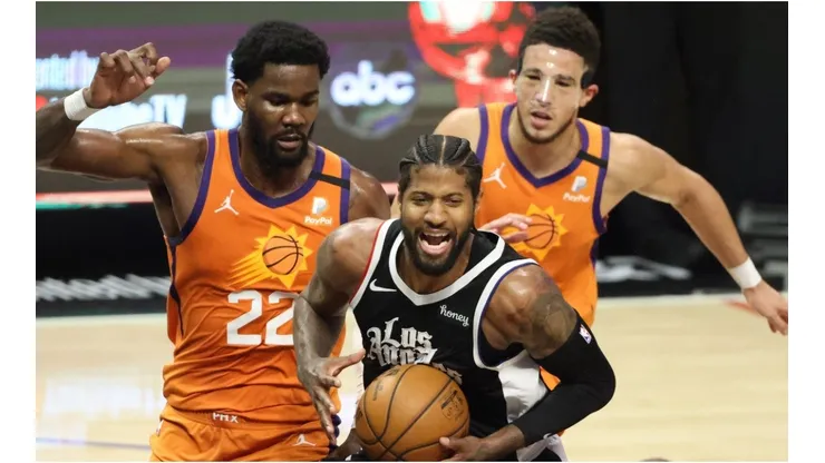 Deandre Ayton and Devin Booker guarding Paul George. (Getty)