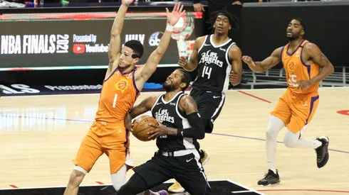 Paul George drives while Devin Booker tries to draw a charge. (Getty)