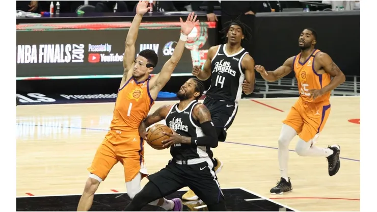Paul George drives while Devin Booker tries to draw a charge. (Getty)