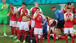 Denmark players look dejected whilst Christian Eriksen receives medical treatment. (Getty)