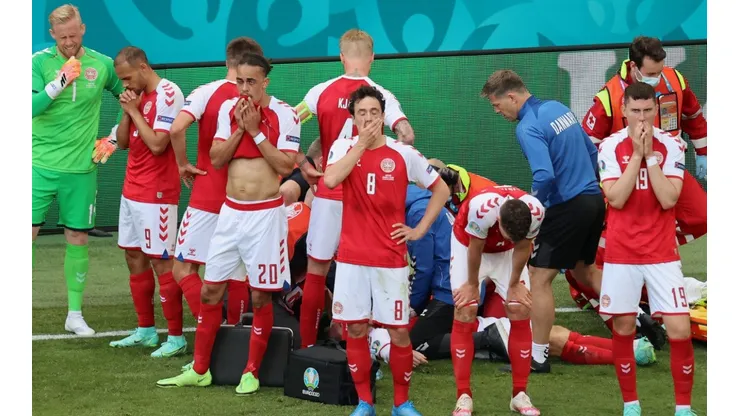 Denmark players look dejected whilst Christian Eriksen receives medical treatment. (Getty)