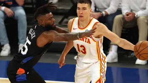 Bogdan Bogdanovic (right) of the Atlanta Hawks passes the ball under pressure from Reggie Bullock (left) of the New York Knicks. (Getty)