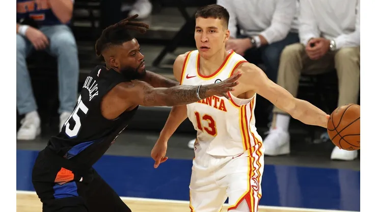 Bogdan Bogdanovic (right) of the Atlanta Hawks passes the ball under pressure from Reggie Bullock (left) of the New York Knicks. (Getty)