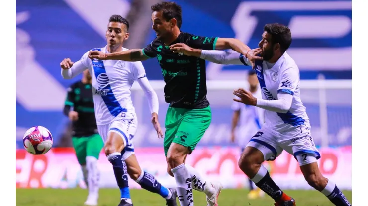 Raúl Rivero (center) of Santos struggles for the ball against Pablo González (right) of Puebla. (Getty)