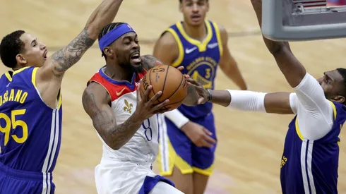 Naji Marshall (center) of the New Orleans Pelicans shoots over Kevon Looney (right) of the Golden State Warriors. (Getty)