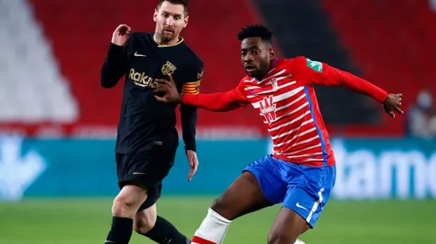 Lionel Messi of Barcelona (left) is tackled by Yan Brice Eteki of Granada (right). (Getty)