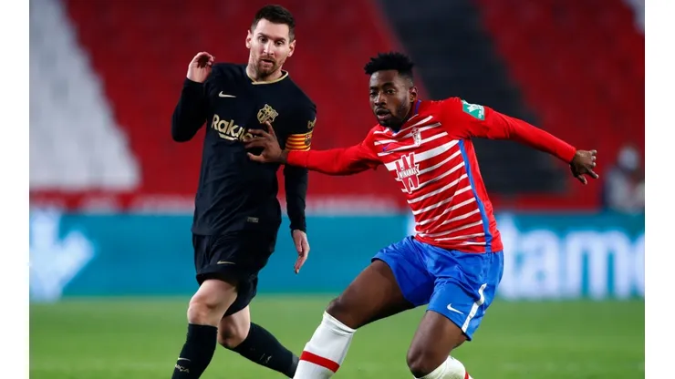 Lionel Messi of Barcelona (left) is tackled by Yan Brice Eteki of Granada (right). (Getty)