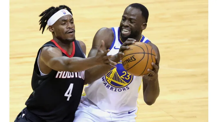 Draymond Green (right) of the Golden State Warriors controls the ball against Danuel House Jr. (left) of the Houston Rockets.
