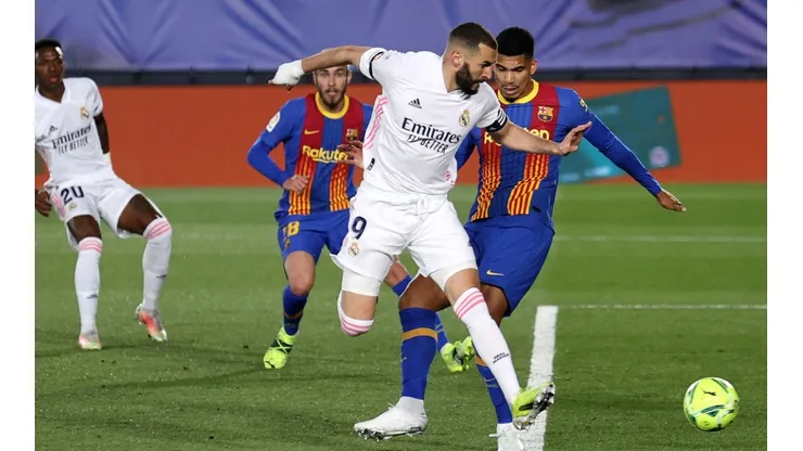 Karim Benzema (centre) of Real Madrid scores a goal vs Barcelona.
