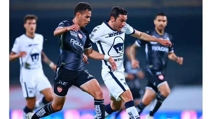 Raul Sandoval (left) of Necaxa struggles for the ball against Juan Vigon (right) of Pumas UNAM.