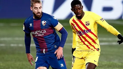 Ousmane Dembélé of Barcelona (right) competes for the ball with Jorge Pulido of Huesca (left). (Getty)