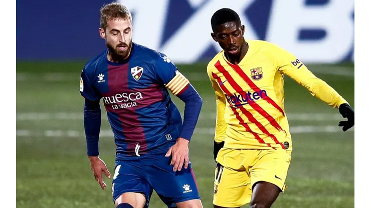 Ousmane Dembélé of Barcelona (right) competes for the ball with Jorge Pulido of Huesca (left). (Getty)