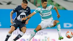 Josecarlos Van Rankin of Santos (right) struggles for the ball with Juan Iturbe of Pumas (left). (Getty)
