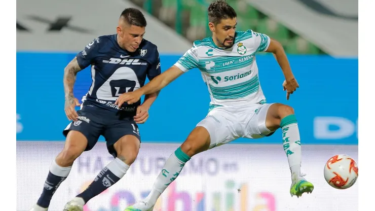 Josecarlos Van Rankin of Santos (right) struggles for the ball with Juan Iturbe of Pumas (left). (Getty)