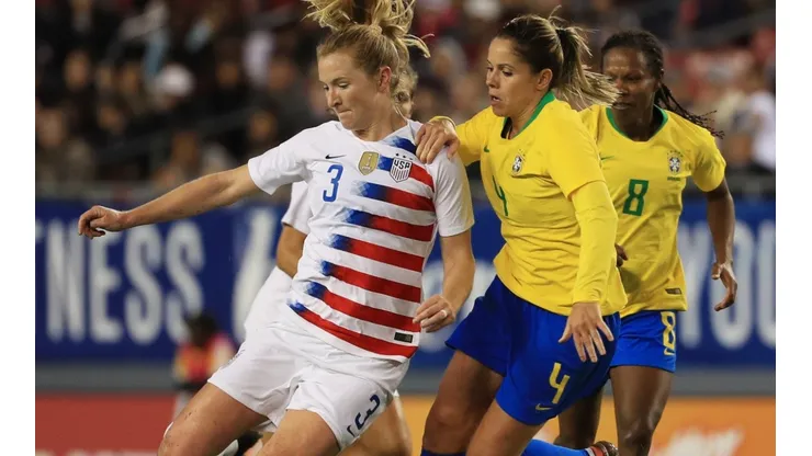 Samantha Mewis (left) of the USA looks to pass the ball over Erika (right) of Brazil. (Getty)