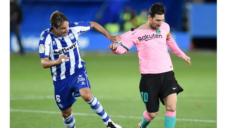 Tomas Pina (left) of Deportivo Alaves pulls the shirt of Lionel Messi (right) of Barcelona. (Getty)