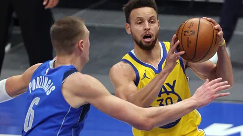 Stephen Curry (right) of the Golden State Warriors takes a shot against Kristaps Porzingis (left) of the Dallas Mavericks. (Getty)