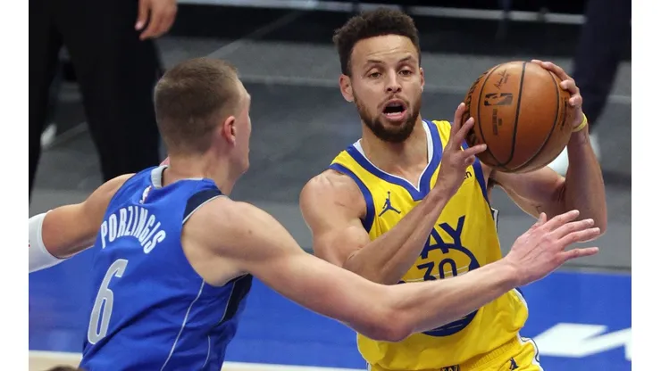 Stephen Curry (right) of the Golden State Warriors takes a shot against Kristaps Porzingis (left) of the Dallas Mavericks. (Getty)