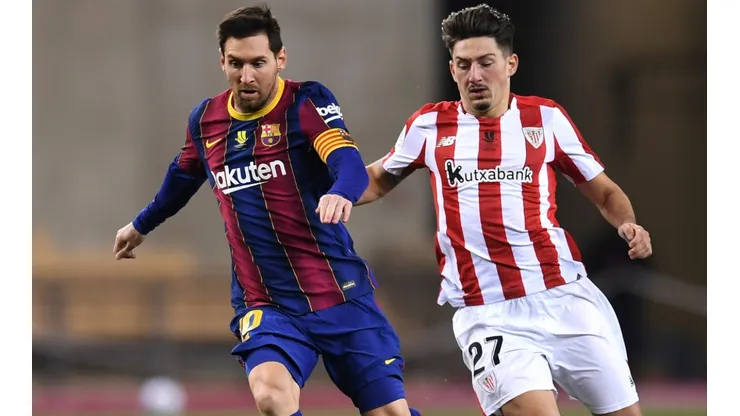 Lionel Messi (left) of Barcelona runs with the ball whilst under pressure from Unai Vencedor (right) of Athletic Bilbao. (Getty)