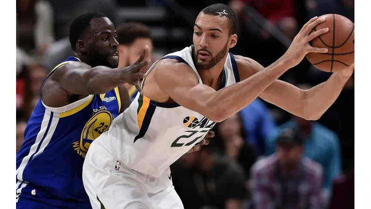 Draymond Green (left) of the Golden State Warriors defends against Rudy Gobert (right) of the Utah Jazz. (Getty)
