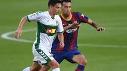 Jony Alamo (left) of Elche battles for possession with Sergio Busquets (ritgh) of Barcelona. (Getty)