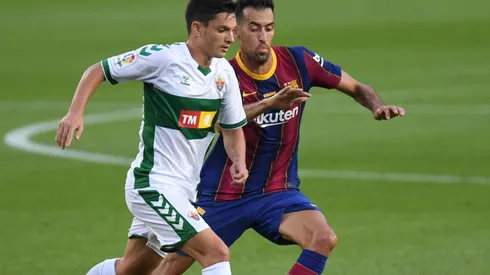 Jony Alamo (left) of Elche battles for possession with Sergio Busquets (ritgh) of Barcelona. (Getty)