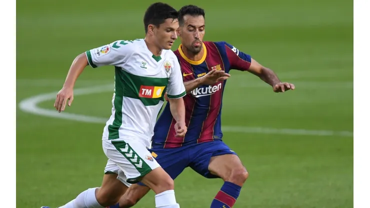 Jony Alamo (left) of Elche battles for possession with Sergio Busquets (ritgh) of Barcelona. (Getty)