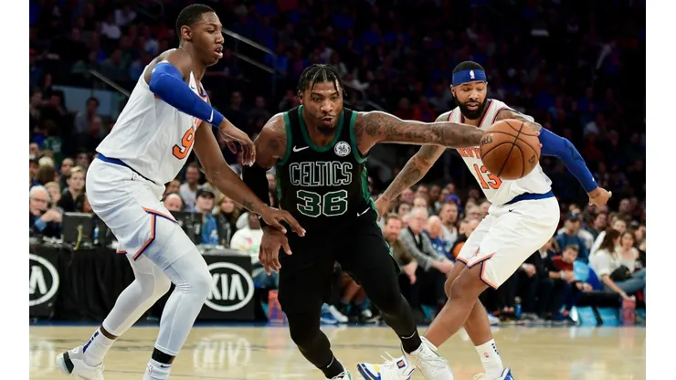 RJ Barrett (left) of the New York Knicks guards Marcus Smart (centre) of the Boston Celtics. (Getty)
