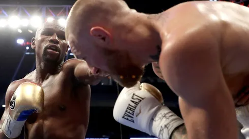Floyd Mayweather (left) throws a punch at Conor McGregor (right) during their super welterweight boxing match. (Getty)