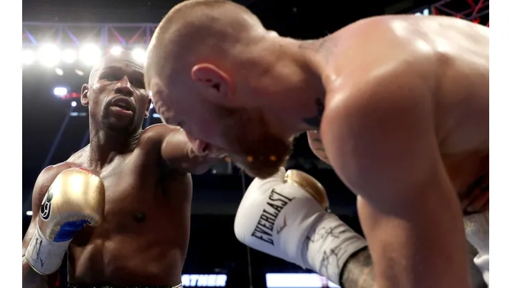 Floyd Mayweather (left) throws a punch at Conor McGregor (right) during their super welterweight boxing match. (Getty)