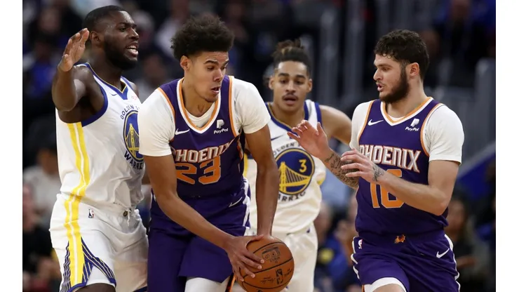 Cameron Johnson (centre) and Tyler Johnson (right) of the Phoenix Suns are guarded by Eric Paschall (left) of the Golden State Warriors. (Getty)