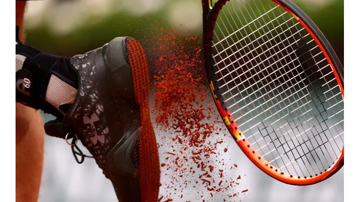Andy Murray of Great Britain bangs clay from his shoes against John Isner of the United States. (Getty).jpg