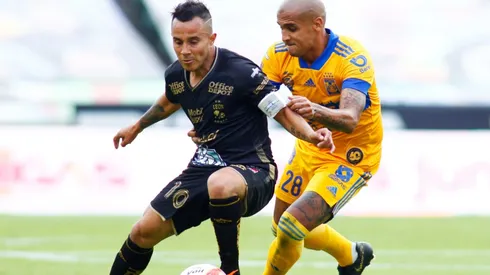 Luis Montes of Leon (left) struggles for the ball with Luis Alfonso Rodriguez of Tigres UANL (right). (Getty)