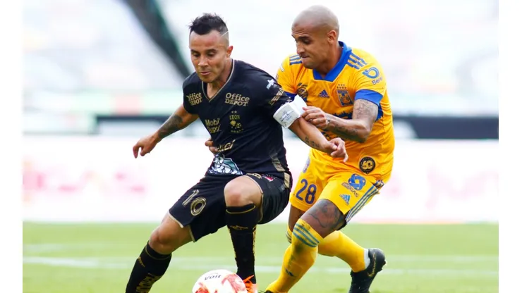 Luis Montes of Leon (left) struggles for the ball with Luis Alfonso Rodriguez of Tigres UANL (right). (Getty)
