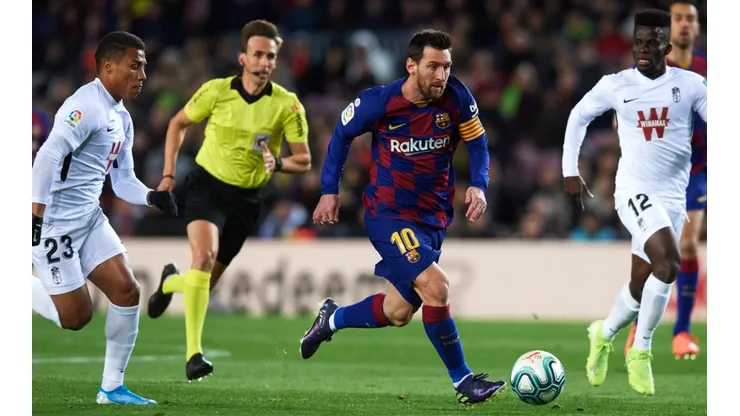 Lionel Messi of FC Barcelona (cenre) runs with the ball under pressure from Darwin Machis (left) and Ramon Azeez (right) of Granada CF. (Getty)