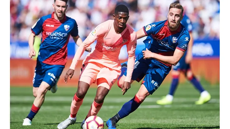 Ousmane Dembele of FC Barcelona (centre) duels for the ball with Jorge Pulido of SD Huesca (right). (Getty)
